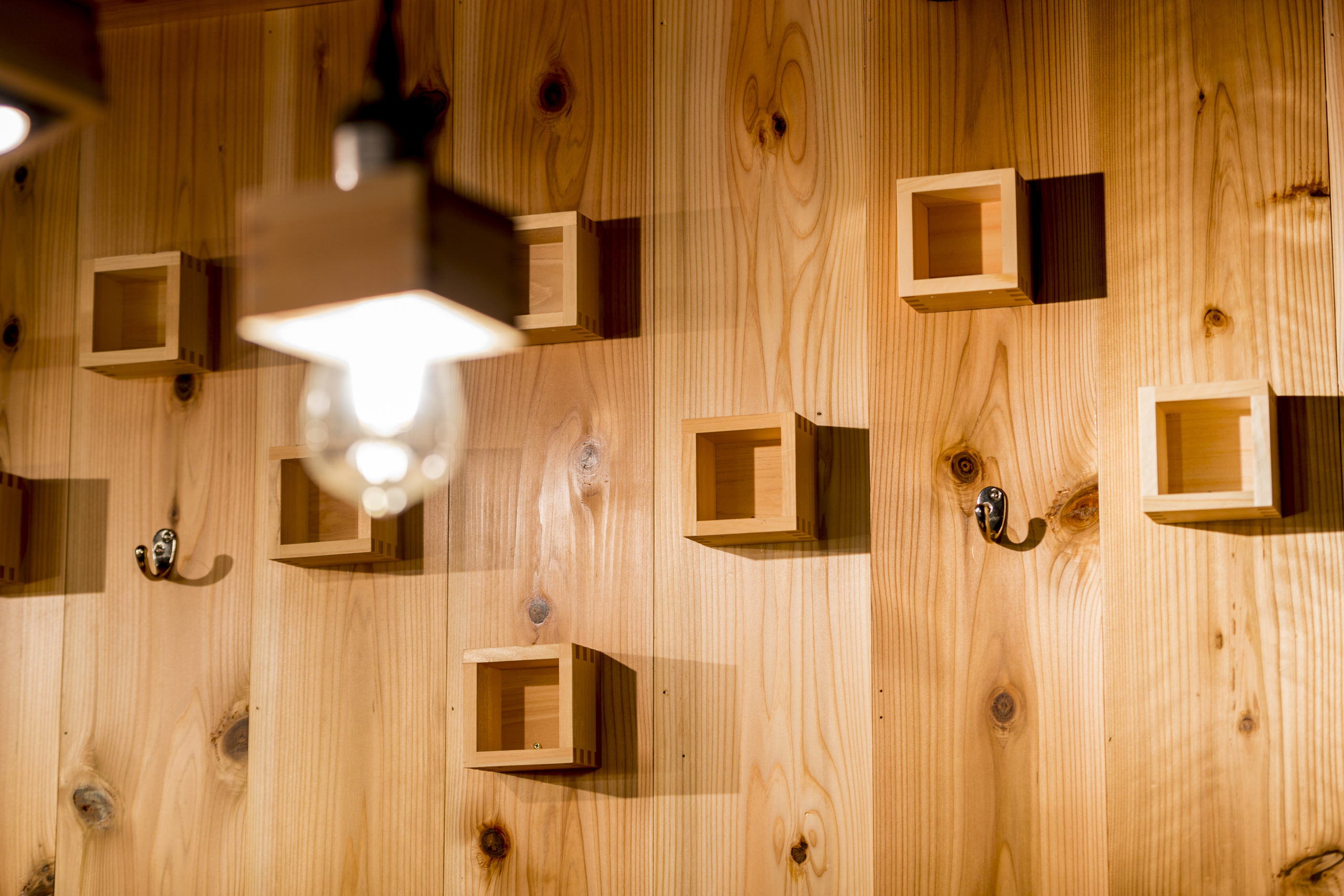 リノベーションした居酒屋の木質空間にアクセントでアクセントとして使用された枡の内装。